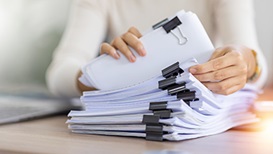 woman going through paperwork on desk